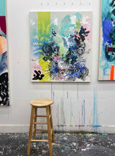 Load image into Gallery viewer, Burn original painting by Tania LaCaria displayed hanging on a white wall in the artist&#39;s studio featuring a wood stool in the foreground
