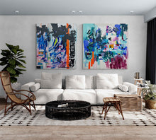 Load image into Gallery viewer, Long Lost and Same Place original paintings hanging on the wall of a large livin room with comfortable contemporary white sofa and rattan accent chairs and a ficus plant.